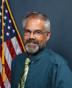 Brian Bruchey in front of flag
